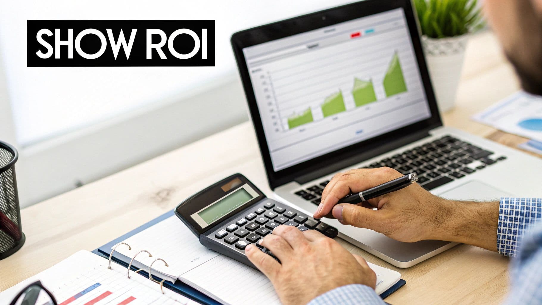 A person calculates ROI on a calculator with a laptop displaying charts, showing business analysis.